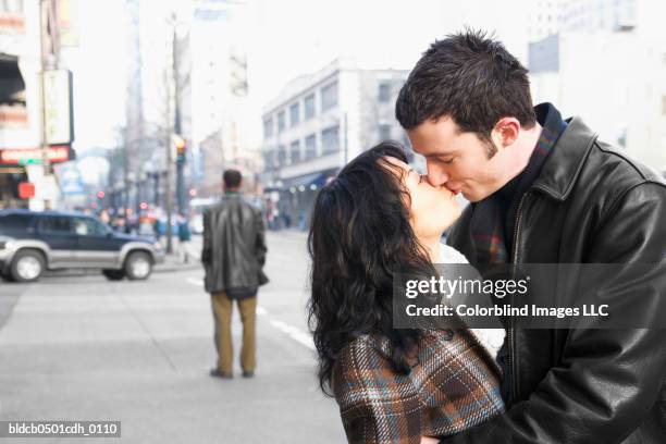 side profile of a mid adult couple kissing on the street - couple close up street stock pictures, royalty-free photos & images