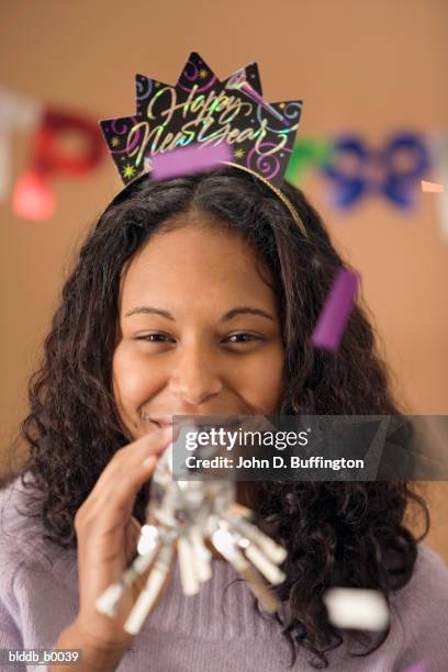 close-up of a teenage girl blowing a party horn blower - escrita ocidental imagens e fotografias de stock