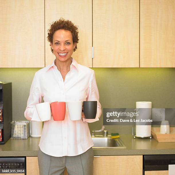 portrait of a mid adult woman holding coffee cups - dave and les jacobs stock-fotos und bilder