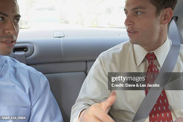 close-up of two businessmen sitting in the back seat of a car - dave and les jacobs stock-fotos und bilder