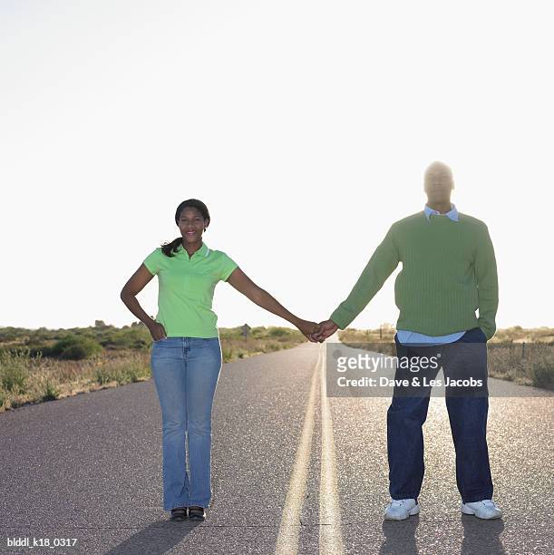 portrait of a mid adult couple holding hands on the road - dave and les jacobs stock-fotos und bilder