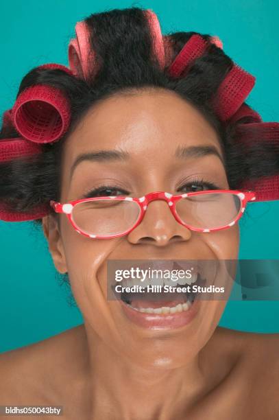 portrait of a young woman wearing curlers in her hair - hair curlers stockfoto's en -beelden