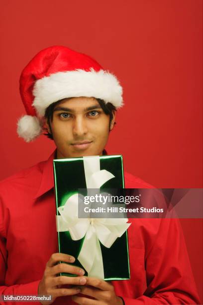 portrait of a young man holding a gift - hill street studios stock-fotos und bilder