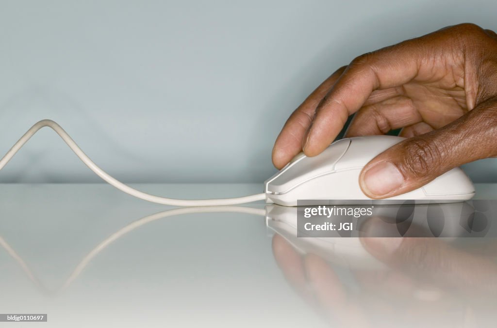 Human hand operating a computer mouse