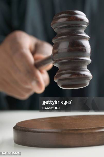 human hand holding a gavel - prejuizo imagens e fotografias de stock