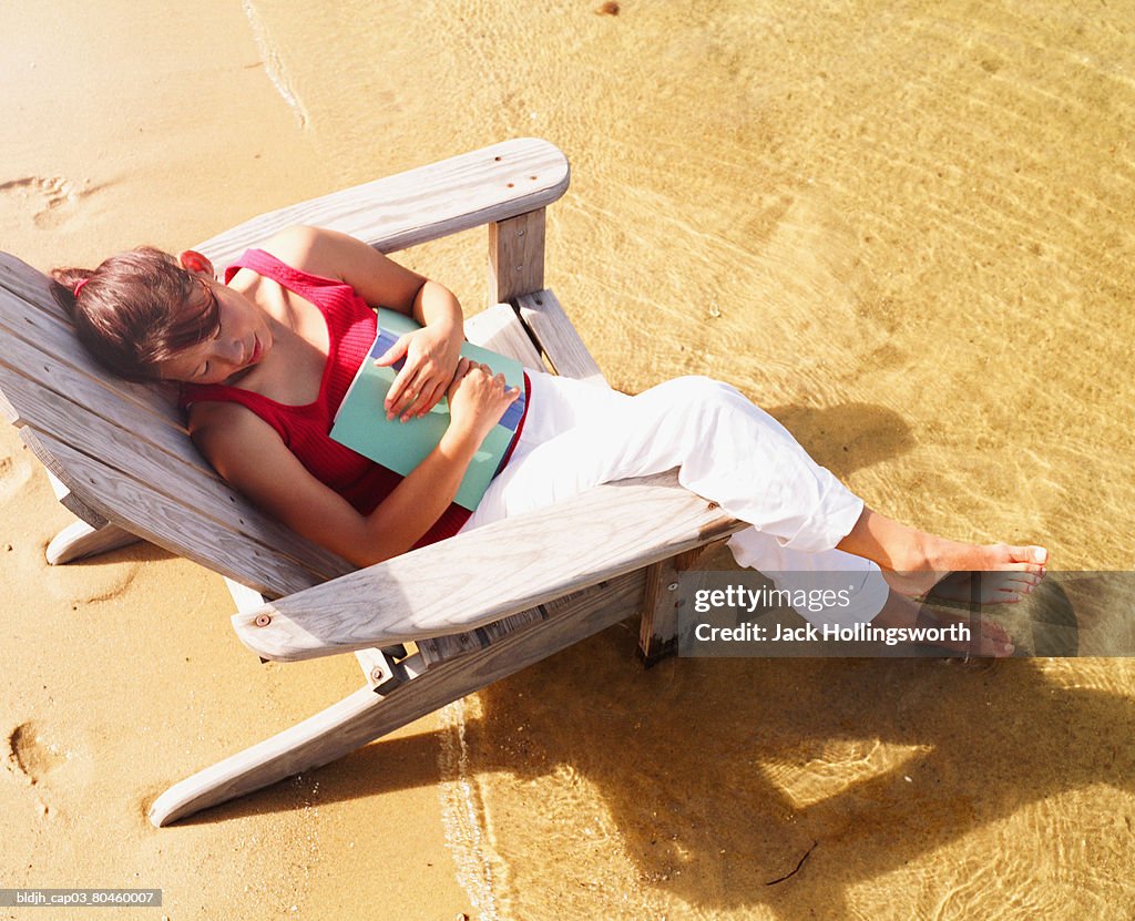 High angle view of a young woman sitting on a beach chair