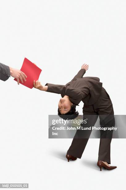 businesswoman bending over backward and handing a file - leaning back stock pictures, royalty-free photos & images