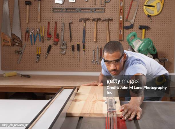 carpenter cutting wooden plank in a workshop - tool rack stock pictures, royalty-free photos & images