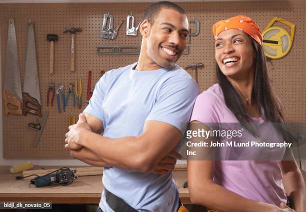 young couple standing in a workshop smiling - tool rack stock pictures, royalty-free photos & images