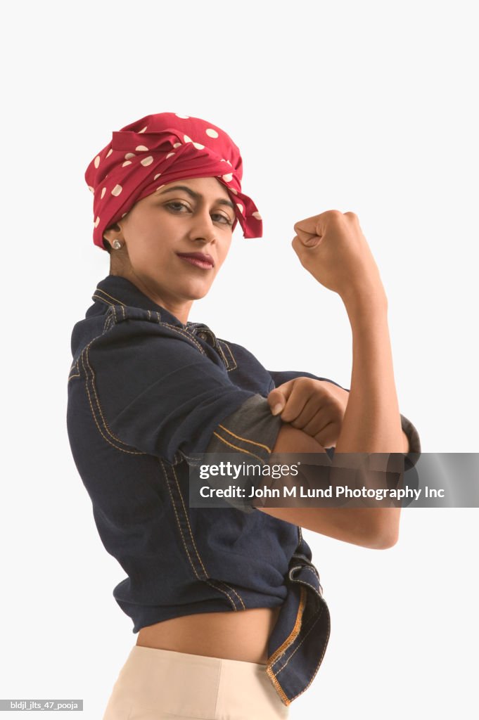 Side profile of a young woman flexing her arm muscle
