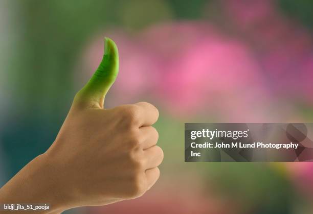 close-up of a young woman's green thumb - john lund ストックフォトと画像