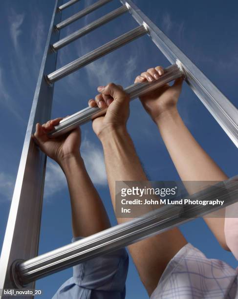 low angle view of three people holding a ladder - john lund ストックフォトと画像