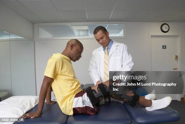 arthritic patient undergoing physical therapy in a hospital - john lund stock-fotos und bilder