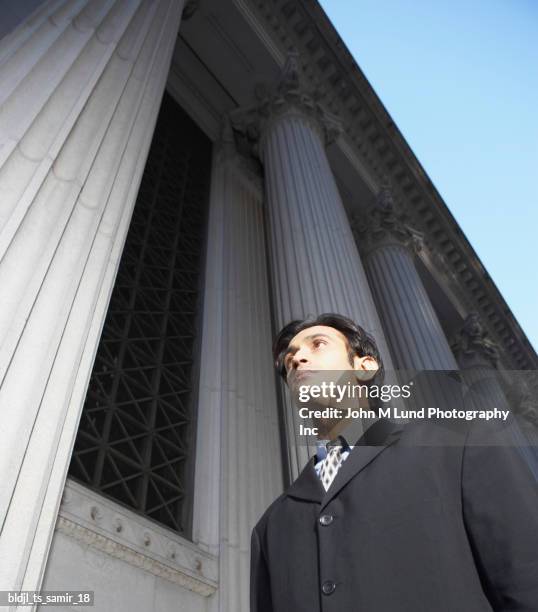 low angle view of a mid adult man standing outdoors - john lund stock-fotos und bilder