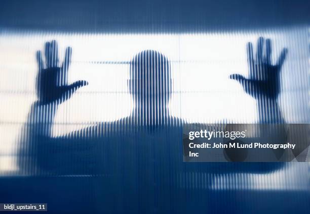 mid adult man standing behind frosted glass - lund stockfoto's en -beelden