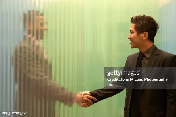 two businessmen shaking hands - frosted glass stock pictures, royalty-free photos & images