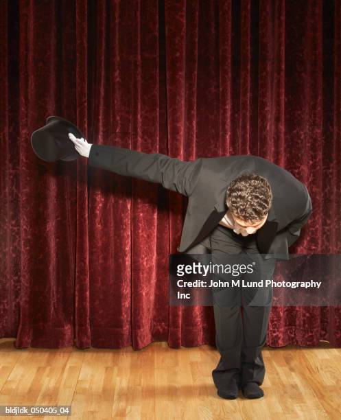 magician bowing on stage - saluer en s'inclinant photos et images de collection