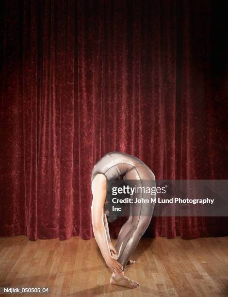 side profile of a female gymnast performing on stage - lund stockfoto's en -beelden