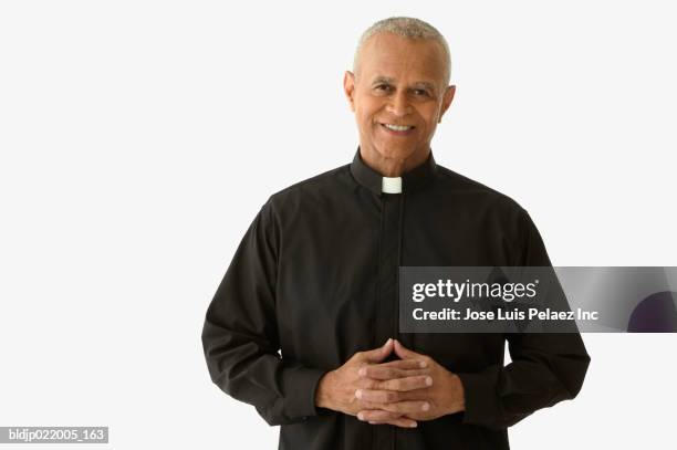 portrait of a priest smiling - geestelijken stockfoto's en -beelden