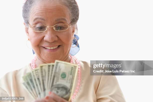 close-up of a senior woman holding paper currency - kärleken till pengar bildbanksfoton och bilder