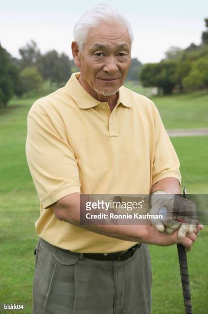 portrait of a senior man at a golf course - golf short iron stock pictures, royalty-free photos & images