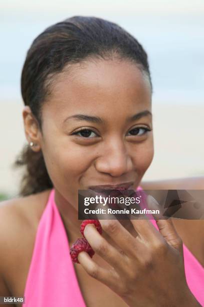 portrait of a young woman with berries on the tips of her fingers - ronnie kaufman stockfoto's en -beelden