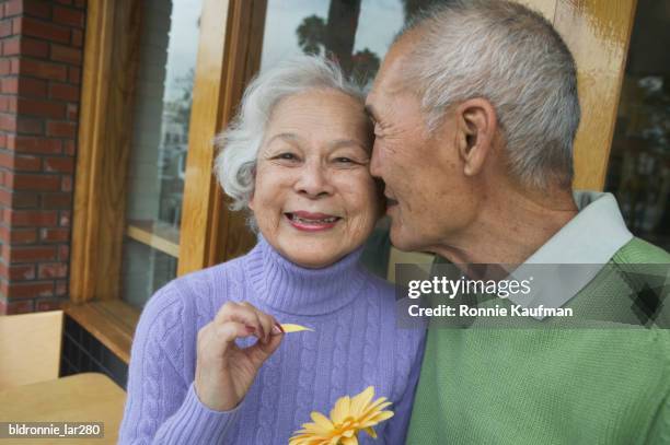 senior man kissing a senior woman - 花びら占い ストックフォトと画像