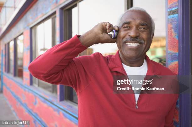 mature man talking on a mobile phone - ronnie kaufman stockfoto's en -beelden