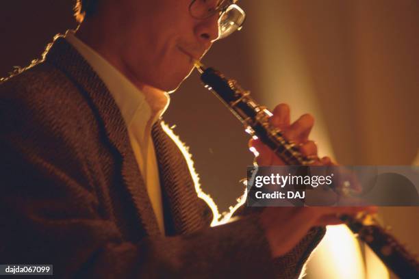 man playing a oboe - oboe stock-fotos und bilder