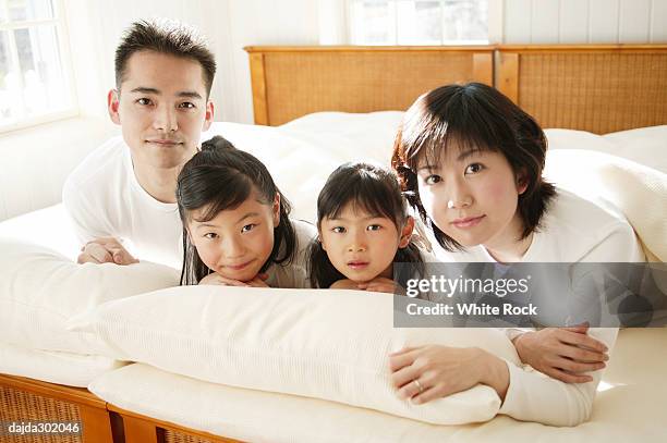 family sprawling in the bed - sprawling stock pictures, royalty-free photos & images