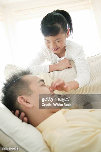 child waking up her father - pinching nose stockfoto's en -beelden