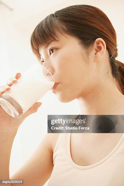 young woman drinking a milk - forza fotografías e imágenes de stock