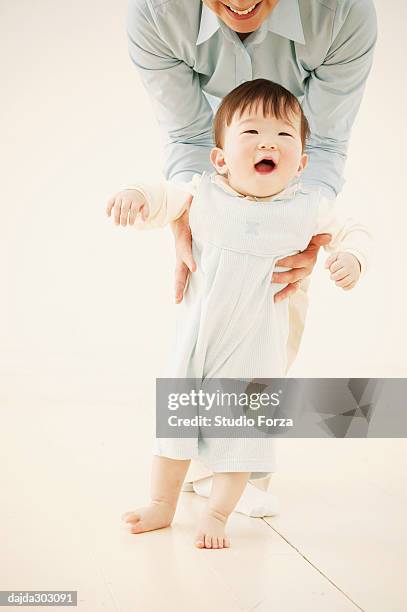 mother holding her daughter - forza fotografías e imágenes de stock