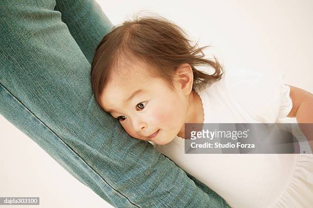 a baby girl holding her mother's feet - forza fotografías e imágenes de stock