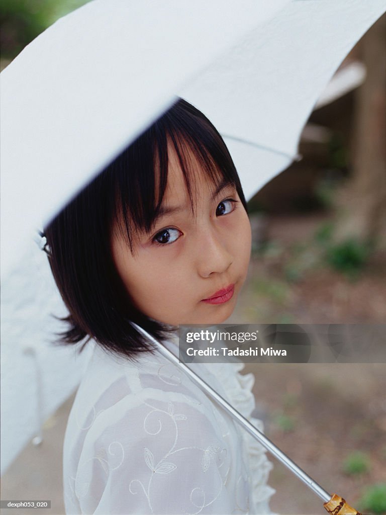 Young girl holding umbrella, portrait