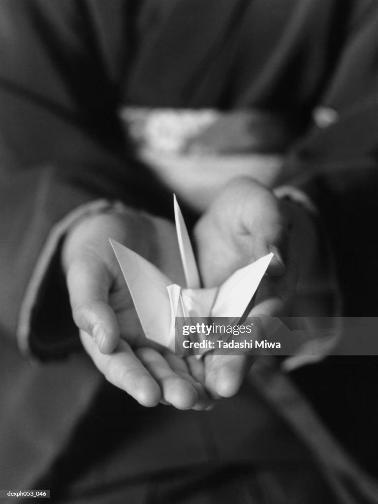 Hands holding Origami crane