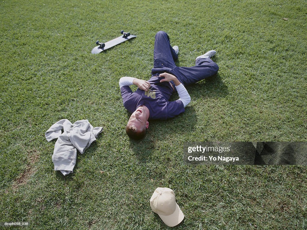 Young man lying on grass