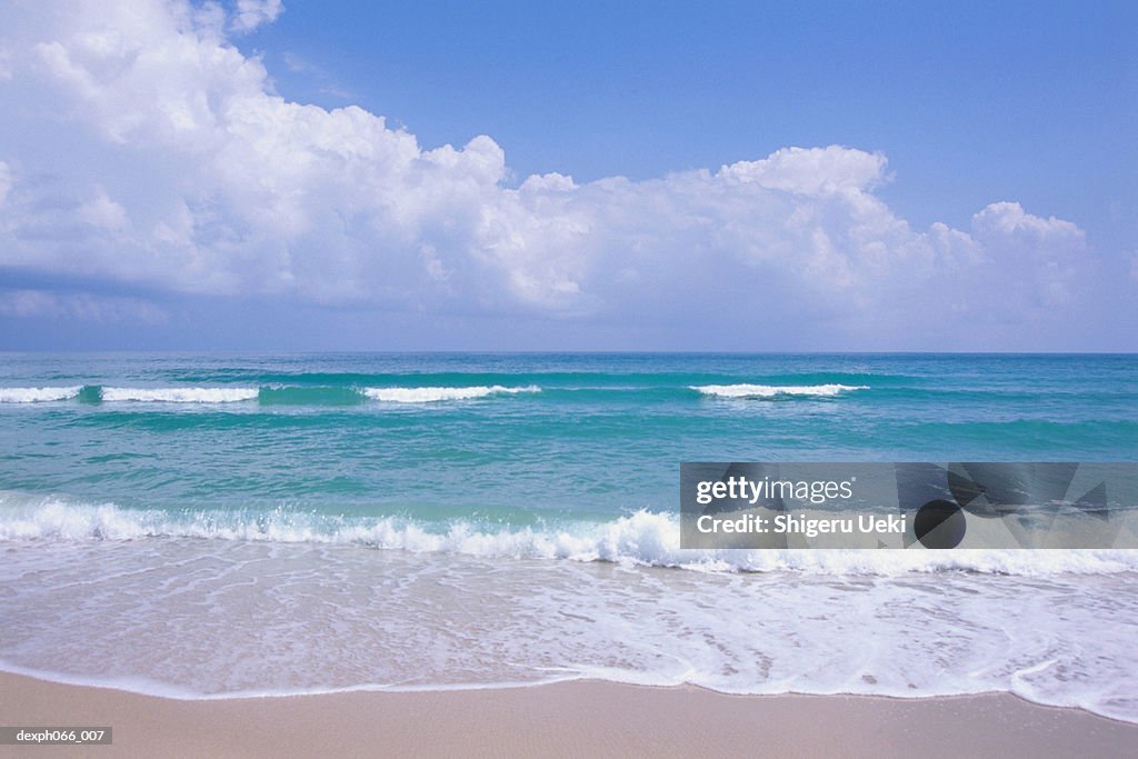 Ocean waves foaming onto sandy beach