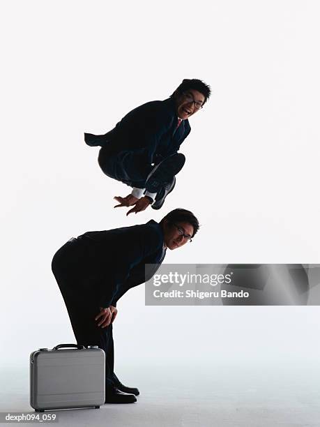 businessmen leap-frogging - bockspringen stock-fotos und bilder