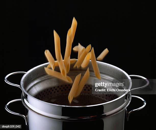 mostaccioli falling into pot - mostaccioli stock pictures, royalty-free photos & images