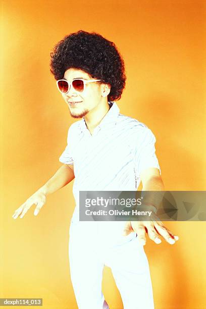 young asian male with afro hair in dancing pose - henry stockfoto's en -beelden
