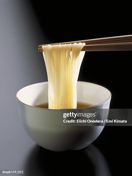 chopsticks picking noodles from bowl - somen noodles imagens e fotografias de stock