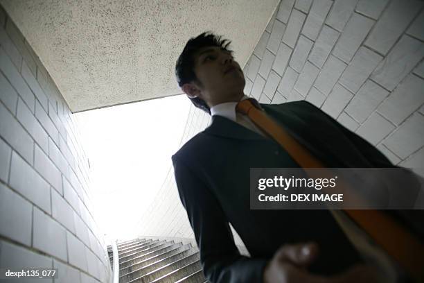 low angle view of a young businessman coming down a flight of stairs - people coming of age purify with icy water in tokyo stockfoto's en -beelden