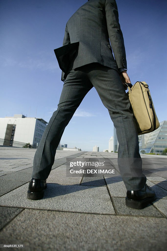 Low angle view of a young businessman holding a briefcase