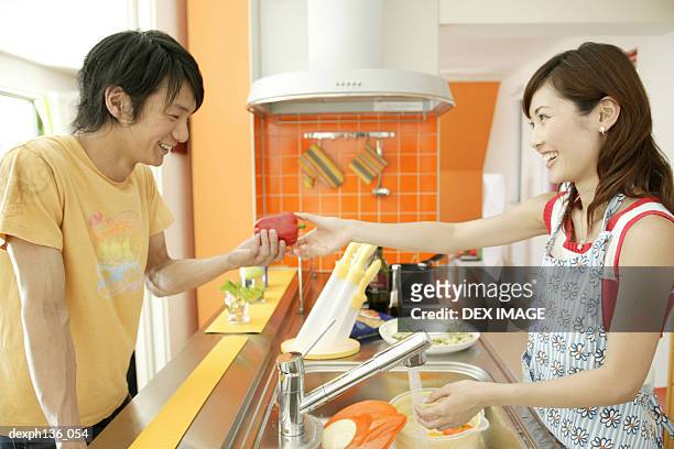 young couple washing in the kitchen - wash bowl fotografías e imágenes de stock