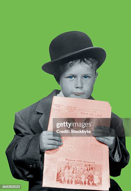 boy dressed in man's derby hat and jacket holding a newspaper - imitación de adultos fotografías e imágenes de stock