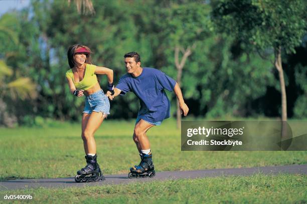 couple in-line skating - inline skating man park stock pictures, royalty-free photos & images