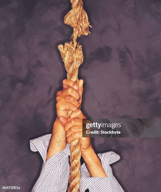 businessman holding fraying rope - chemise bigarrée photos et images de collection