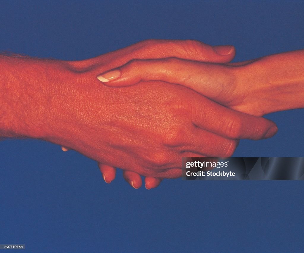 Businessman and woman, handshake, blue background, grain effect