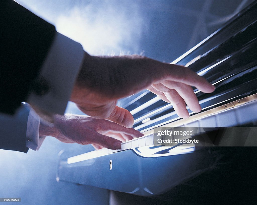 Hands playing piano keys